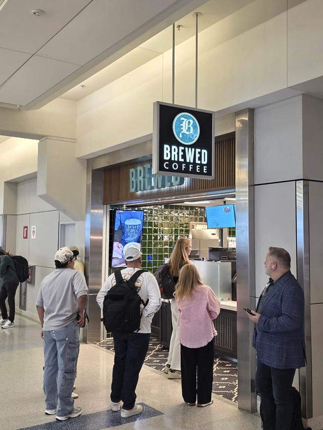 A line forms at the newly opened BREWED coffee shop located near gate E18 in Terminal E of DFW Airport.